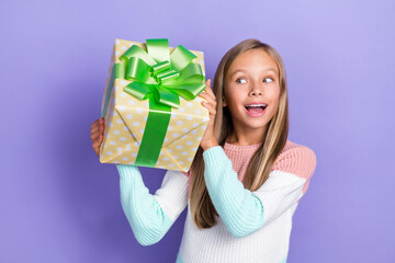 Wall Mural - Photo of excited cheerful girl dressed stylish sweater hand hold box interested look what inside isolated on purple color background