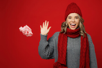 Wall Mural - Young happy health woman wears grey sweater scarf hat throw away pink napkin tissue isolated on plain red background studio portrait Healthy lifestyle ill sick disease treatment cold season concept.