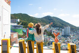 Fototapeta Sypialnia - Woman traveller is sightseeing and looking at Gamcheon Culture Village in Busan, South Korea.