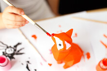 A Little Girl Paints A Toy Fox Made Of Clay. DIY Concept