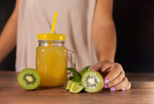 Natural Juice Mug On A Wooden Table.With Kiwi And Lime. With Woman And Background.