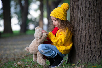  Portrait of a little girl  is playing in the park in autumn
