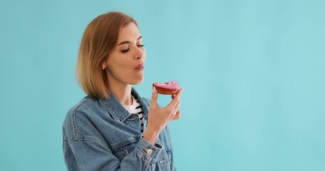 Wall Mural - beautiful blonde woman eating with pleasure donuts