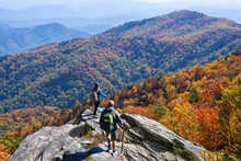 Couple Hiking In Autumn Mountains. Friends On Top Of The Mountain Enjoying Beautiful Fall Scenery. Blue Ridge Mountains, Near Asheville, North Carolina, USA	

