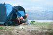 © Robert Petrovic - Attractive male gay couple camping by the sea under amazing mountain view. Hipsters homosexuals enjoying tenderness moment in a tent on empty beach. LGBT vacation in Autumn.