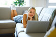 © Louis-Photo - Happy teenager girl online with a laptop in the living room at home