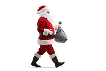 Canvas Print - Full length profile shot of santa claus walking and carrying a plastic bin bag