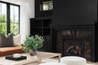 © Joseph Hendrickson - A cozy living room detail shot with a leather couch and wood table in front of a black built-in shelving and fireplace.