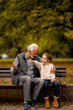 © BGStock72 - Grandfather spending time with his granddaughter on bench in park on autumn day