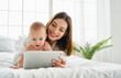 Mother and child on the bed communicate via video link.