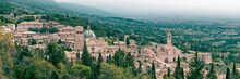 Panoramic High-angle Of Basilica Di Santa Chiara With Forested Mountains And Foggy Sky Background