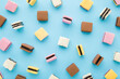 Colorful jelly gummy candies on light blue table background. Pastel color. Sweet snack pattern. Closeup. Top down view.