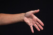 © Gennadi - An outstretched hand for a handshake, isolated on a black background.