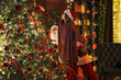 © ZaStock - Little girl with Santa Claus together decorating Christmas tree with toys. New Year concept.