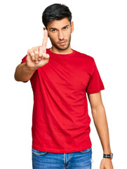 Wall Mural - Young handsome man wearing casual red tshirt pointing with finger up and angry expression, showing no gesture