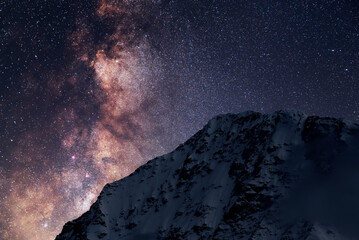 Wall Mural - Night landscape. Beautiful snow covered mountains in the starry night with milky way galaxy.
