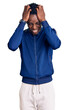 © Krakenimages.com - Young african american man wearing sportswear suffering from headache desperate and stressed because pain and migraine. hands on head.