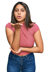 Poster - Young hispanic girl wearing casual t shirt looking at the camera blowing a kiss with hand on air being lovely and sexy. love expression.