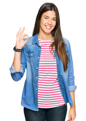 Poster - Young brunette woman wearing casual clothes smiling positive doing ok sign with hand and fingers. successful expression.