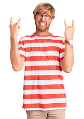 Sticker - Handsome caucasian man with beard wearing casual clothes and glasses shouting with crazy expression doing rock symbol with hands up. music star. heavy concept.