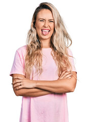 Sticker - Young blonde woman with arms crossed gesture sticking tongue out happy with funny expression.