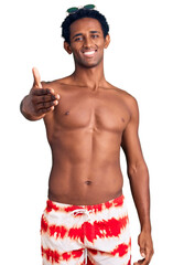 Canvas Print - African handsome man wearing swimsuit and sunglasses smiling friendly offering handshake as greeting and welcoming. successful business.