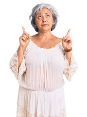 Sticker - Senior woman with gray hair wearing bohemian style pointing up looking sad and upset, indicating direction with fingers, unhappy and depressed.