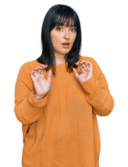 Sticker - Young hispanic woman wearing casual clothes moving away hands palms showing refusal and denial with afraid and disgusting expression. stop and forbidden.