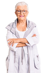 Wall Mural - Senior beautiful woman with blue eyes and grey hair wearing casual clothes and glasses happy face smiling with crossed arms looking at the camera. positive person.