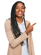 © Krakenimages.com - African american woman wearing business jacket cheerful with a smile on face pointing with hand and finger up to the side with happy and natural expression