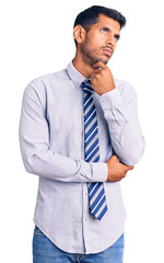 Sticker - Young latin man wearing business clothes serious face thinking about question with hand on chin, thoughtful about confusing idea