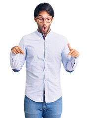 Poster - Handsome hispanic man wearing business shirt and glasses pointing down with fingers showing advertisement, surprised face and open mouth