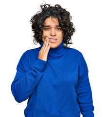 Canvas Print - Young hispanic woman with curly hair wearing turtleneck sweater touching mouth with hand with painful expression because of toothache or dental illness on teeth. dentist