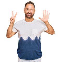 Sticker - Handsome middle age man wearing casual tie dye tshirt showing and pointing up with fingers number seven while smiling confident and happy.