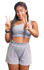 Sticker - Young african american woman with braids wearing sportswear smiling looking to the camera showing fingers doing victory sign. number two.