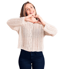 Sticker - Young beautiful blonde woman wearing casual sweater smiling in love doing heart symbol shape with hands. romantic concept.