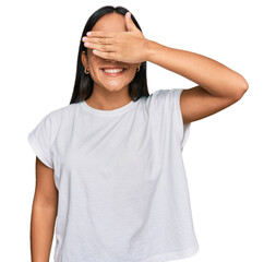 Wall Mural - Young asian woman wearing casual white t shirt smiling and laughing with hand on face covering eyes for surprise. blind concept.
