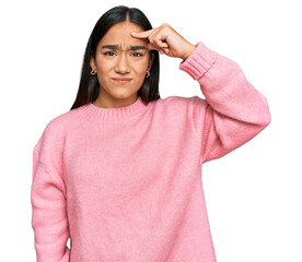 Wall Mural - Young asian woman wearing casual winter sweater pointing unhappy to pimple on forehead, ugly infection of blackhead. acne and skin problem