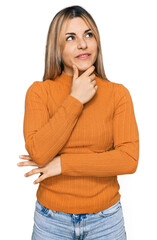 Young caucasian woman wearing casual clothes with hand on chin thinking about question, pensive expression. smiling with thoughtful face. doubt concept.