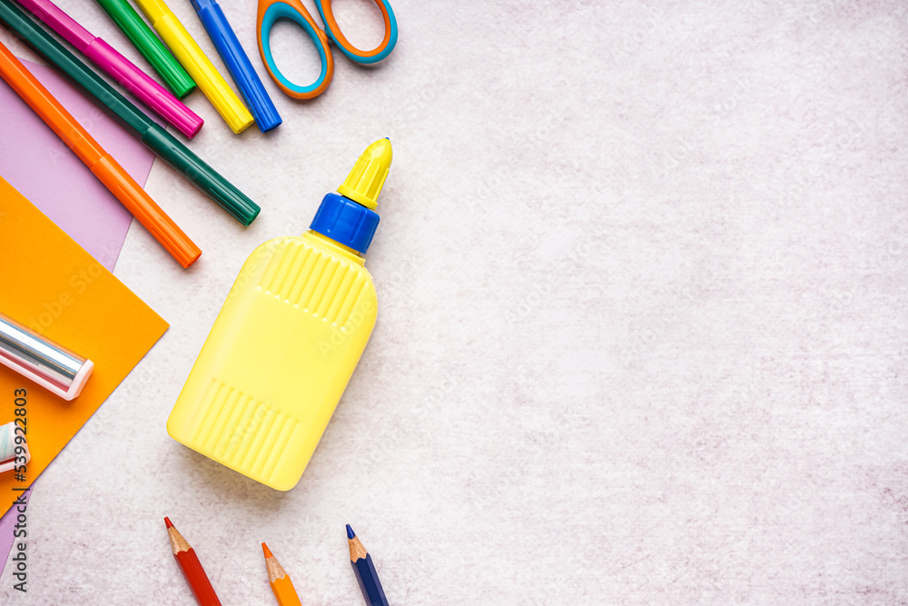 Bottle of glue and stationery on light background