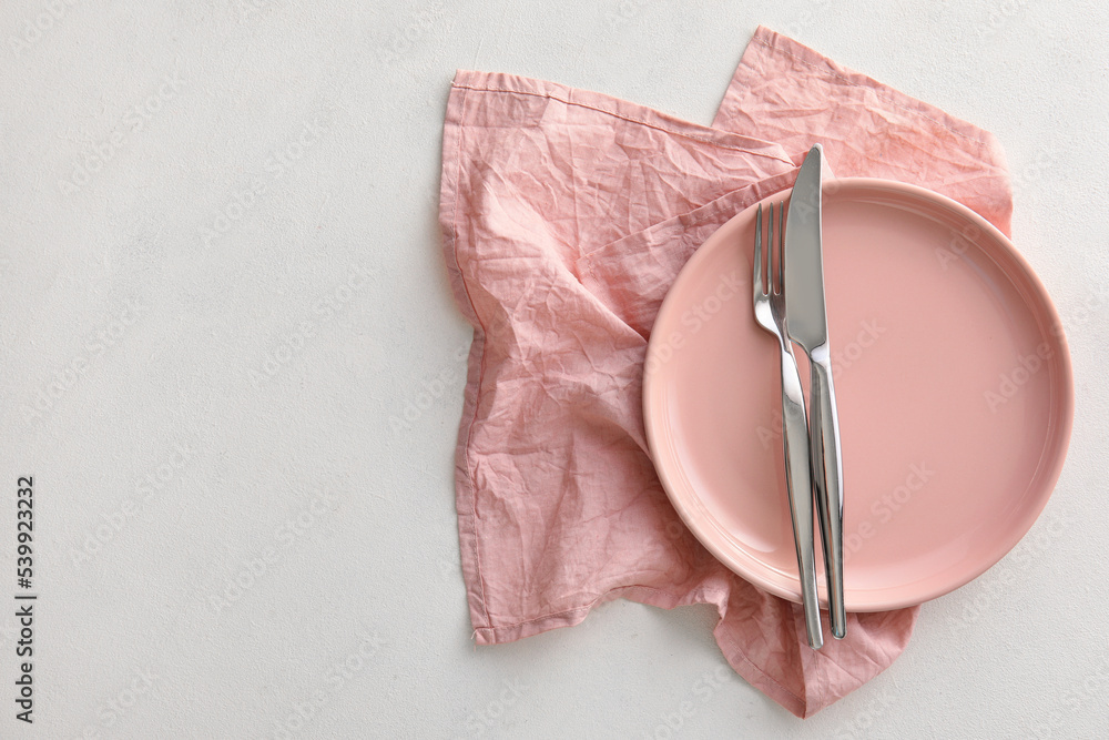 Table setting with plate, napkin and cutlery on white background