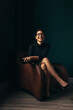 © Jacob Lund - Smiling asian woman sitting on an armchair