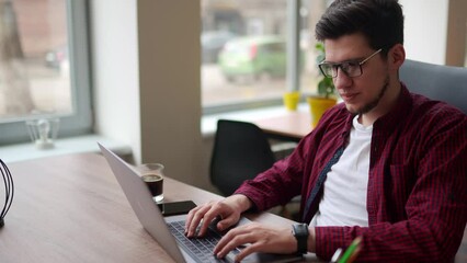 Wall Mural - young freelancer man working with laptop at bright spacious coworking alone. stylish creative design