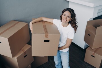 Wall Mural - Smiling female delivery postal service worker holding carton box preparing parcels for sending