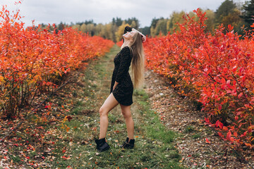 Outdoor blondie woman portrait. Cheerful happy girl in red field in blossom 