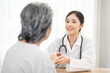 © Wongsakorn - female doctor hanging stethoscope care senior woman and giving hope, holding her hand and smiling. Healthcare concept.