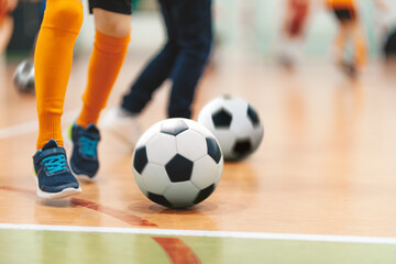 Wall Mural - Futsal Soccer Ball on Indoor Training Pitch. Young Players On Sports Practice Running Balls in Blurred Background. School Sports Class For Kids