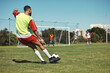 © Allistair F/peopleimages.com - Soccer, sports and men on a field during a game, training or exercise together. Athlete kicking a football during a professional competition, event or sport with team in a park for fitness in summer