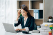 © Kritdanai - Beautiful Asian businesswoman smiling and working happily on her desk in the office.