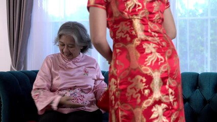 Wall Mural - Young woman give red bag to wish her mother on Chinese New year